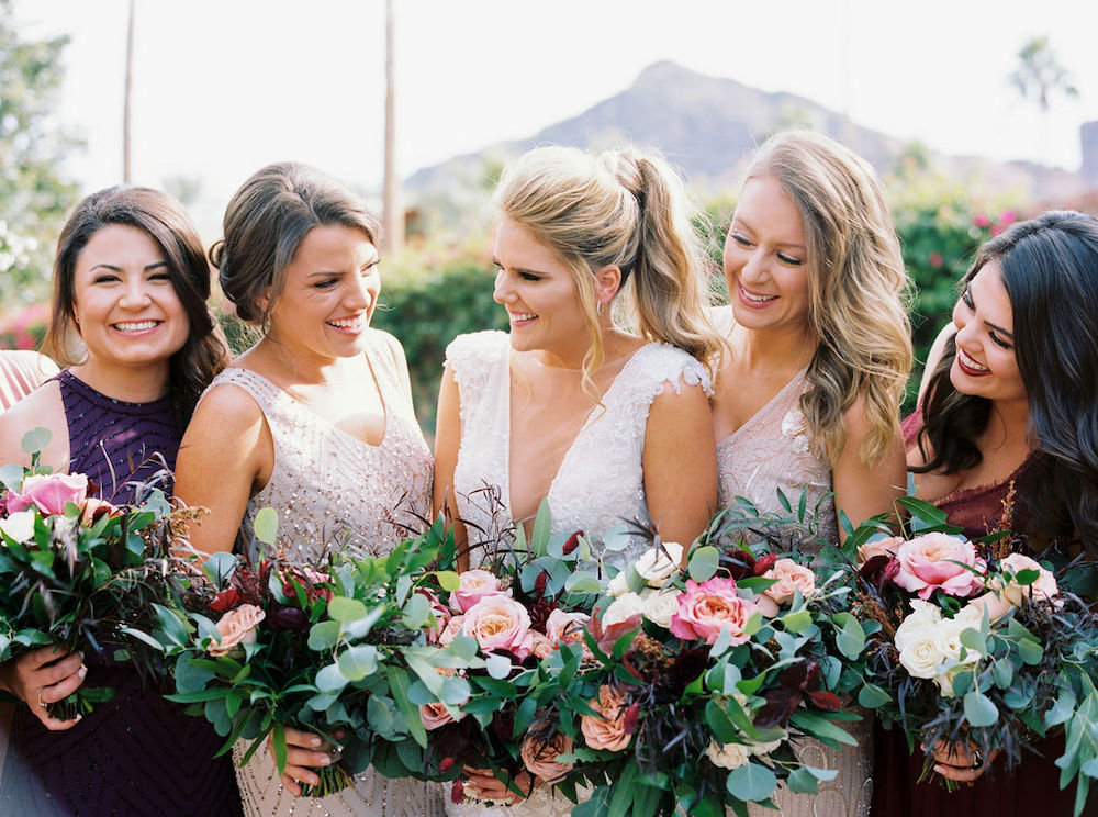 Bride and bridesmaids with blush and burgundy flowers at Omni Scottsdale Resort and Spa at Montelucia.