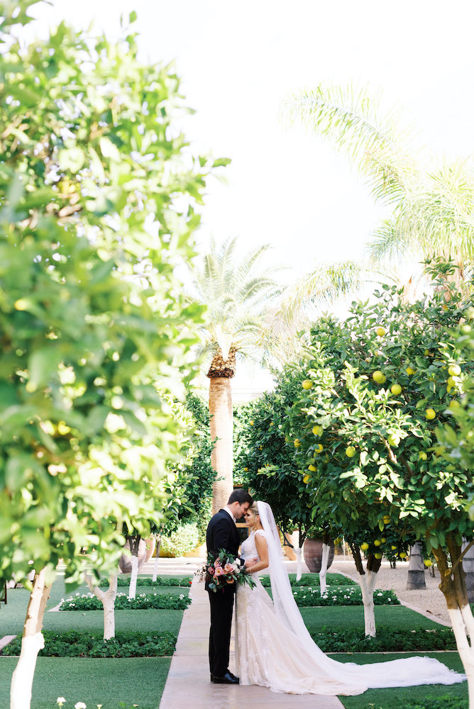 bride and groom posed in orchard at Omni Scottsdale wedding