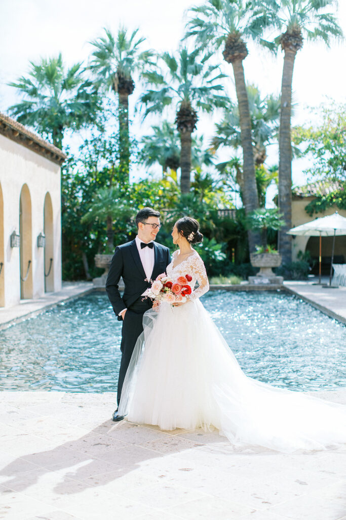 wedding couple portraits in front of resort pool at The Royal Palms